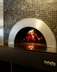 an enclosed Milano fired oven in use, with custom tile pattering around the enclosure.