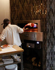 an enclosed Milano fired oven in use, with custom tile pattering around the enclosure.