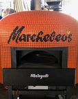 An orange Napoli fired oven with a custom branded tiling for Marcheleos.