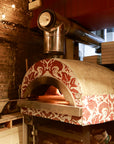 A Roma fired oven with a white and red pattern tile finish.